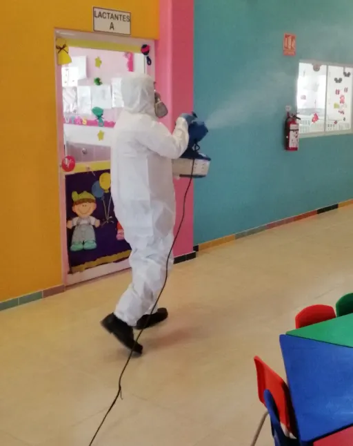 Persona con traje hazmat sanitizando el lugar